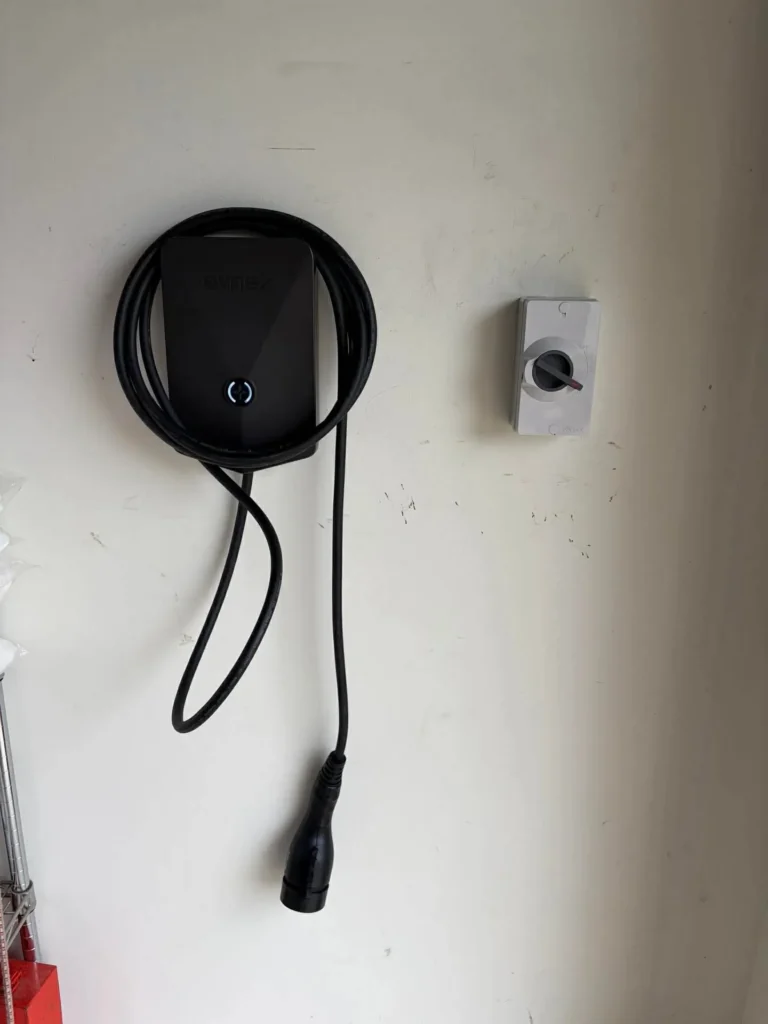 Evnex EV charger mounted on a garage wall with a Voltex isolator switch alongside