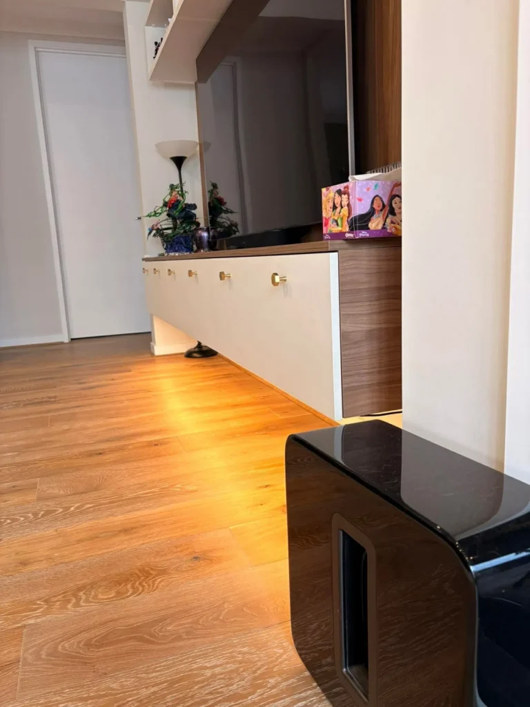 Warm LED strip lighting installed under a hallway sideboard, casting a glow across the timber floor