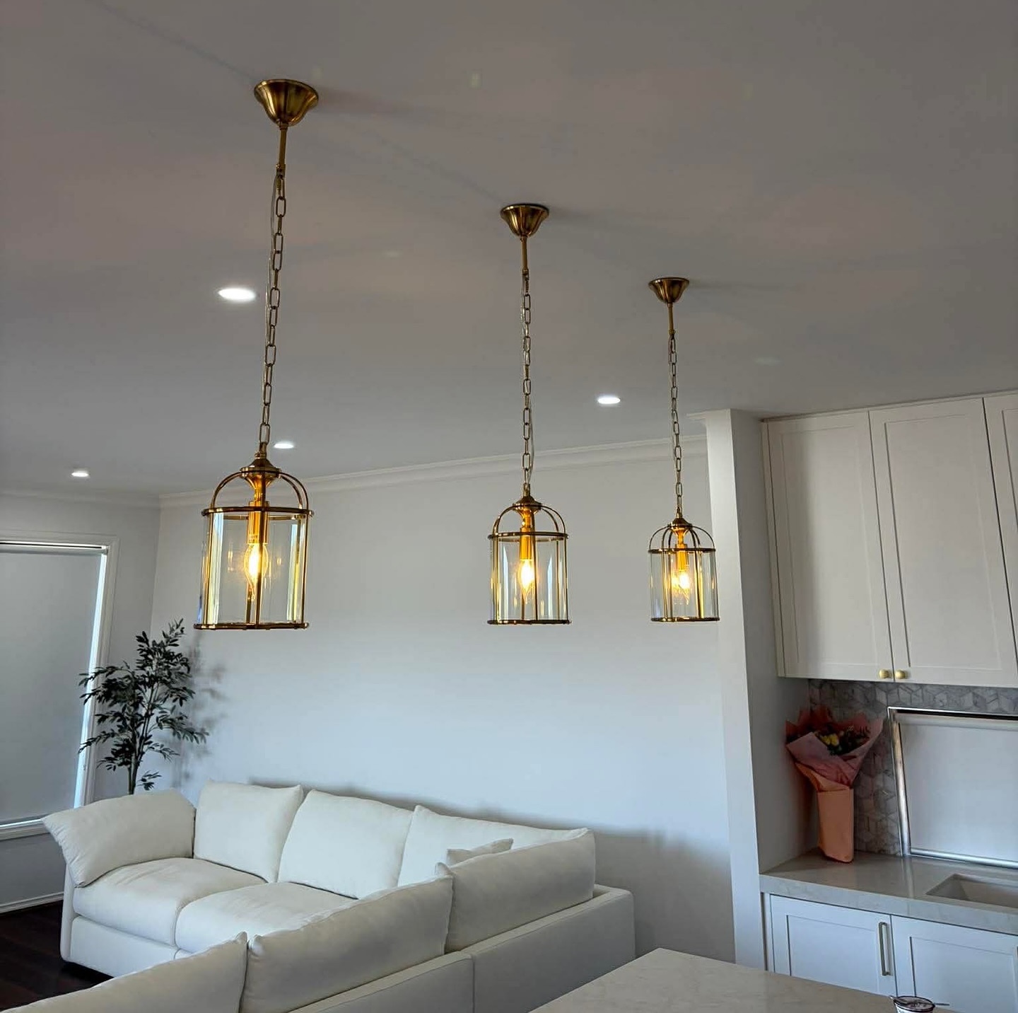 Three brass cage pendant lights over a kitchen island in a Bacchus Marsh home